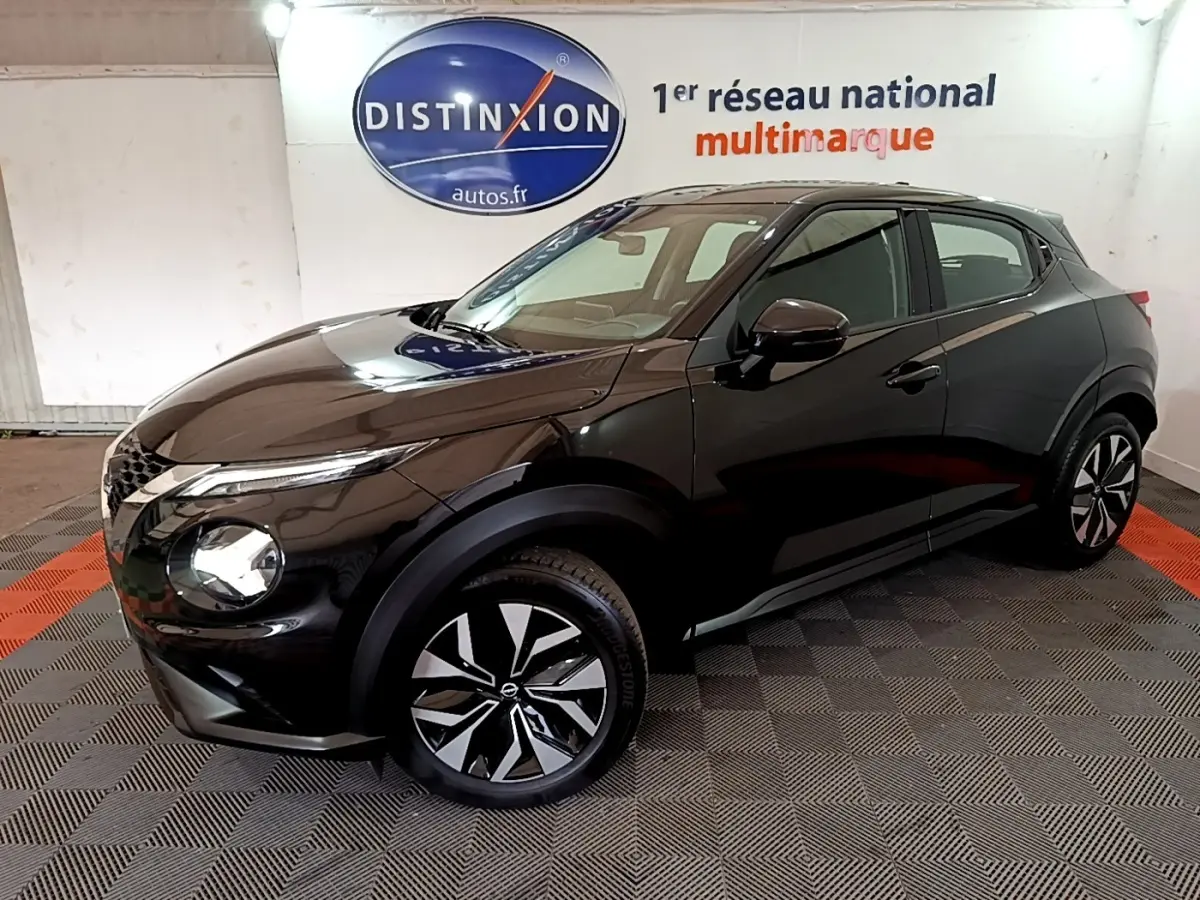 Nissan Juke noir en vue 3/4 avant droit, avec jantes alliage bicolores et phares LED ellipsoïdaux visibles.