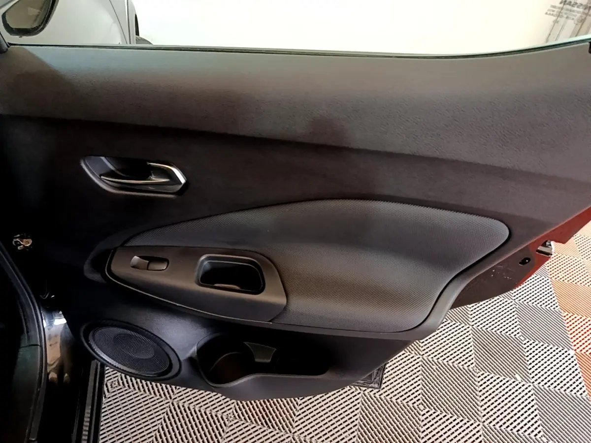 Gros plan sur la porte côté gauche noire du Nissan Juke 2023, avec poignée intégrée et haut-parleur rond visible.