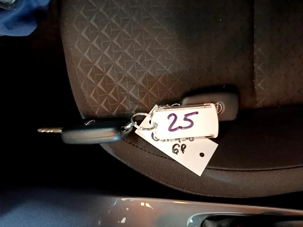 Clé de voiture Nissan posée sur un siège tissu noir à motifs géométriques, vue rapprochée intérieure.