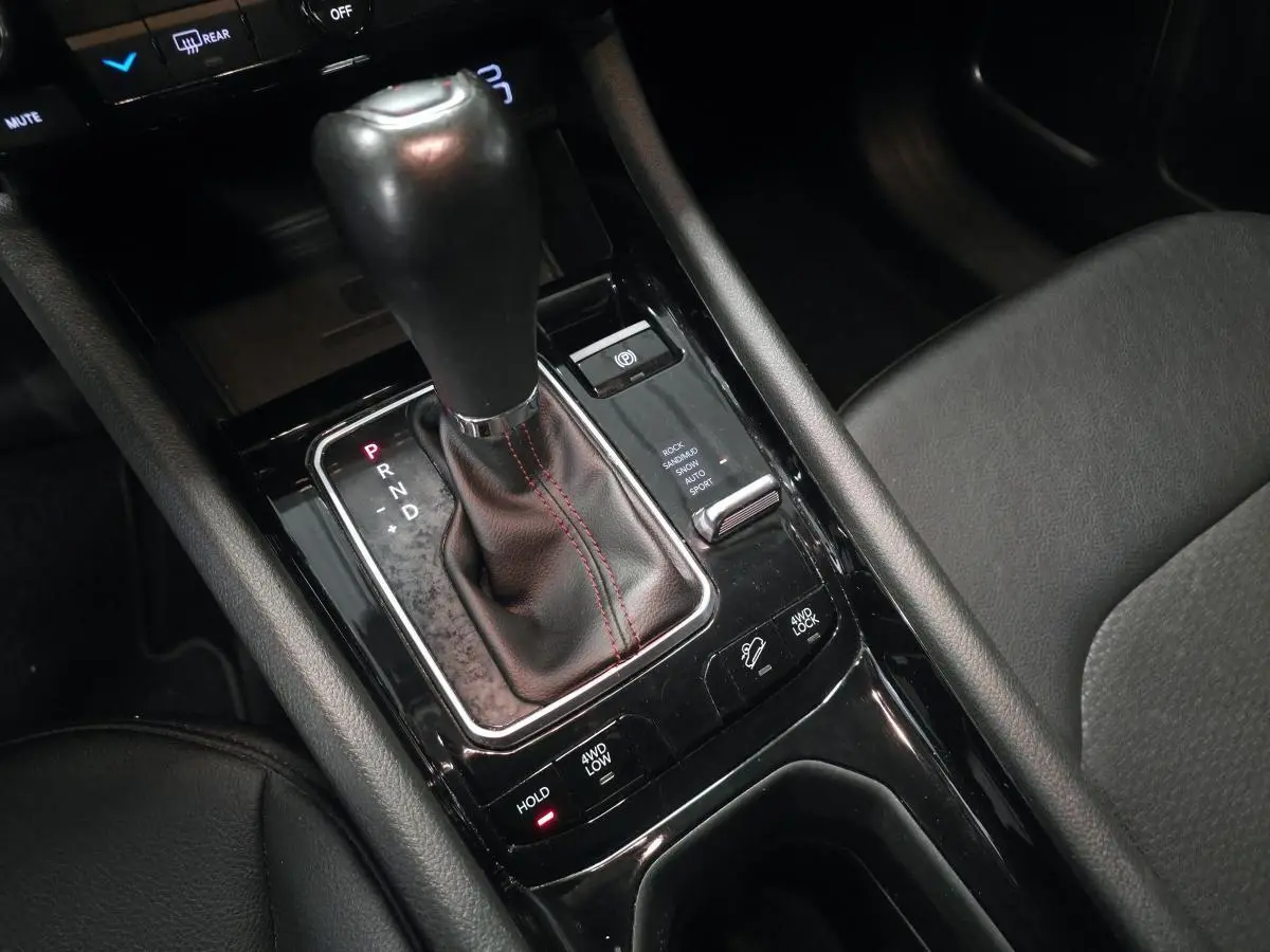 Gros plan sur la console centrale noire du Jeep Compass 2022 avec levier de vitesses automatique et commandes 4WD.