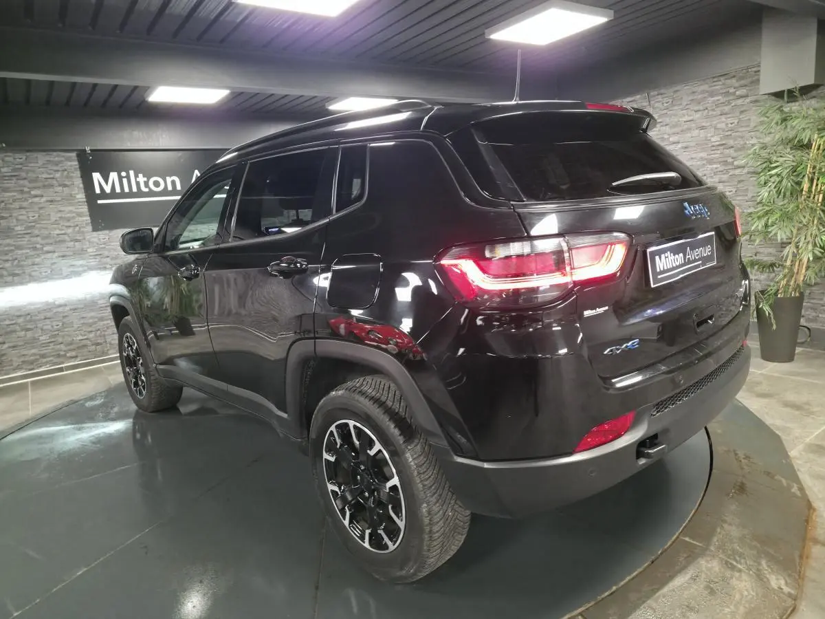 Vue 3/4 arrière droite du Jeep Compass Trailhawk noir avec jantes alliage et badges eAWD visibles.