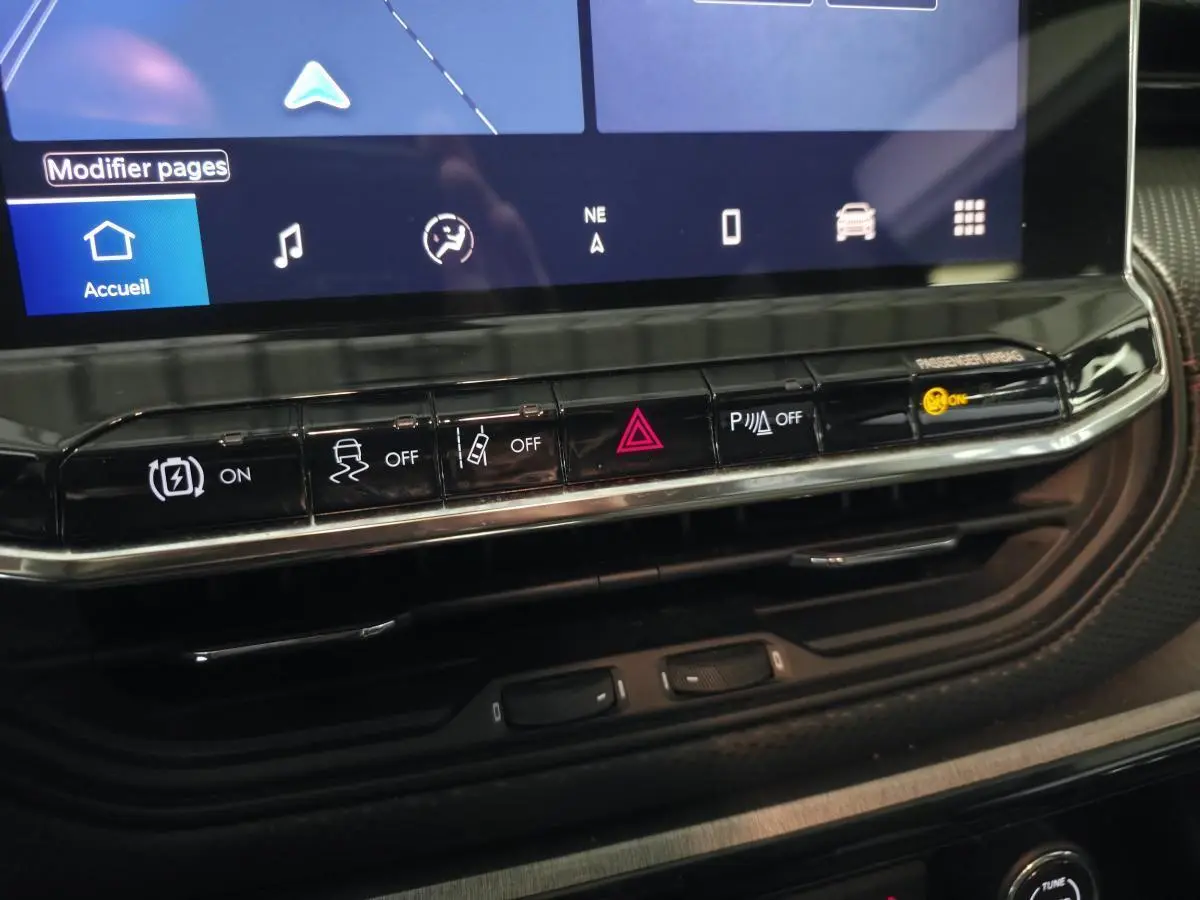 Vue rapprochée du tableau de bord noir du Jeep Compass 2022 montrant les boutons de commande et l'écran tactile.