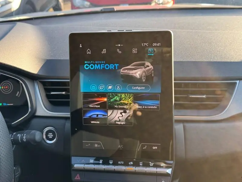 Vue intérieure centrée sur l'écran tactile vertical du tableau de bord du Renault Captur rouge, affichant le mode Confort.