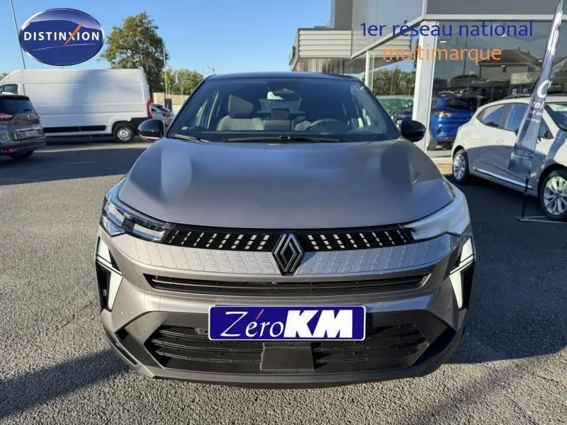 Vue avant d'un Renault Captur gris métallisé avec calandre distinctive et logo Renault bien visible.
