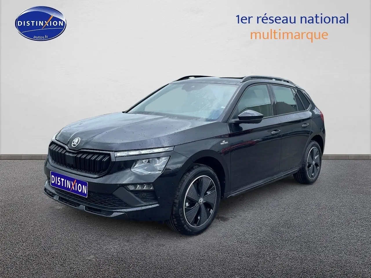 Vue 3/4 avant d'un Skoda Kamiq noir 2026 avec jantes alu et barres de toit, sur fond neutre.
