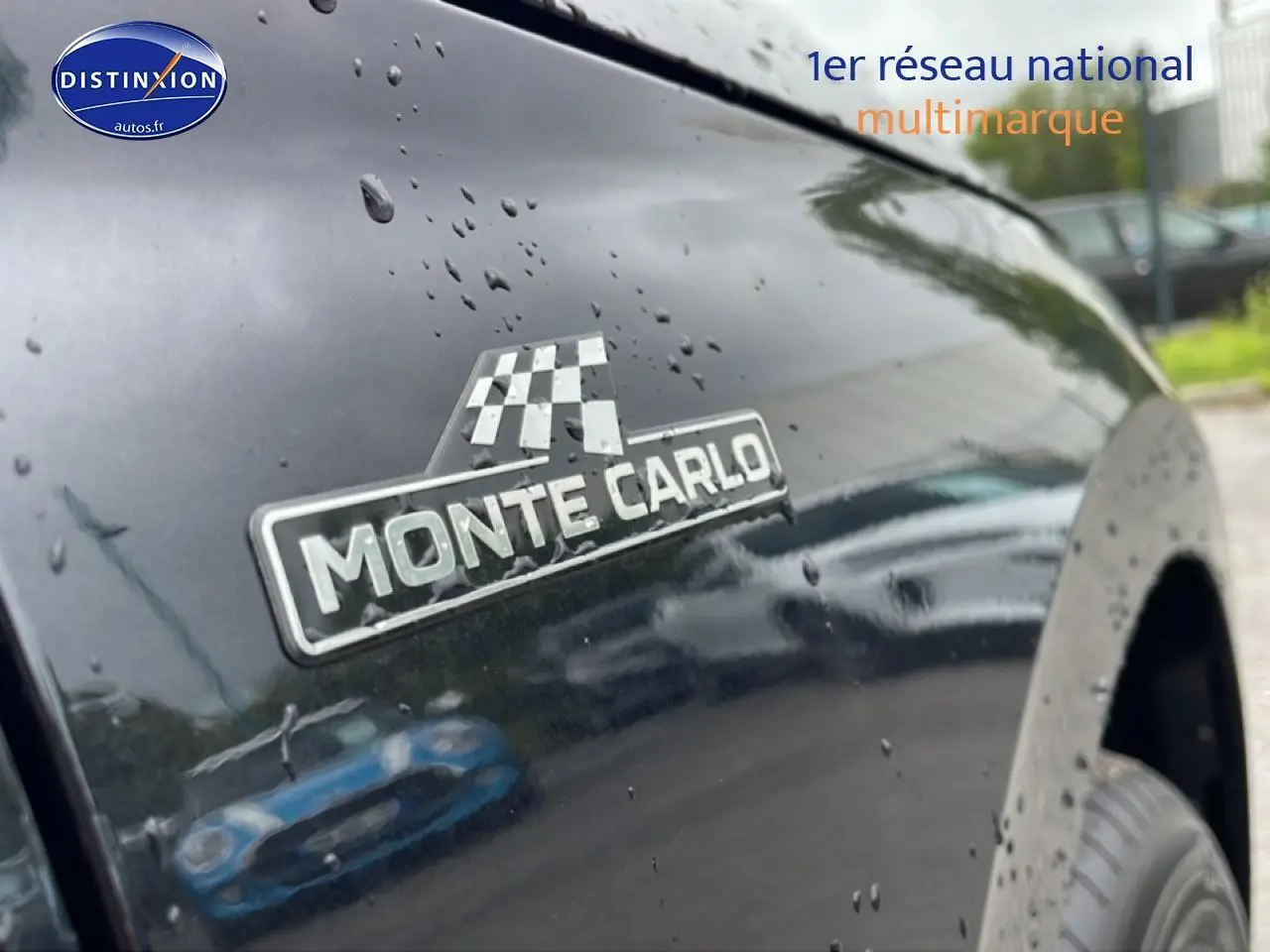 Gros plan sur l'aile avant droite noire d'un Skoda Kamiq Monte Carlo avec logo distinctif sous pluie fine.