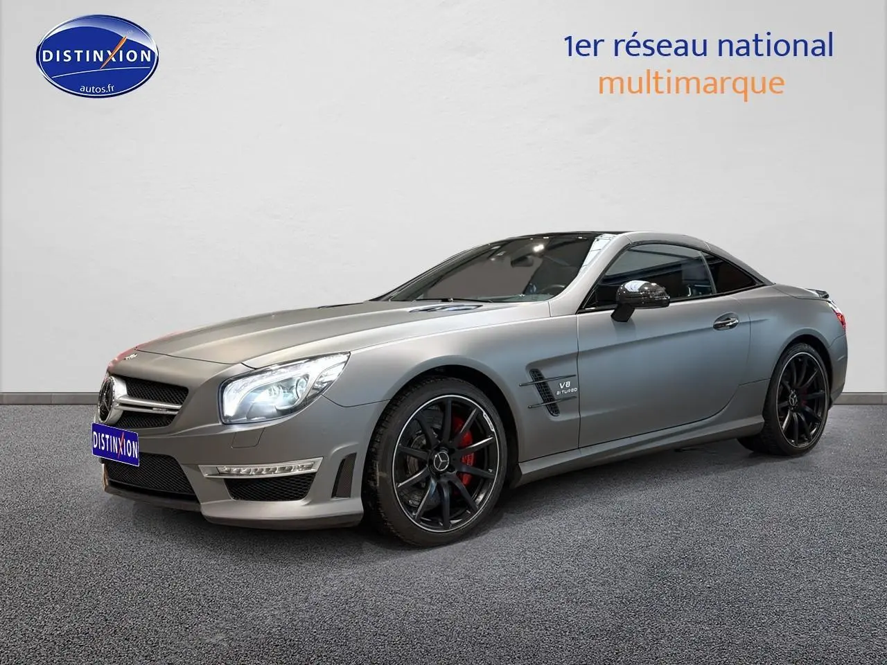 Mercedes Classe SL 63 AMG gris vue 3/4 avant droit avec jantes noires et étriers de frein rouges visibles.