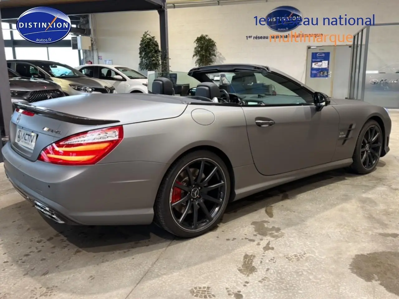 Mercedes Classe SL 63 AMG gris mat vue 3/4 arrière droit, capote ouverte et jantes noires sport.
