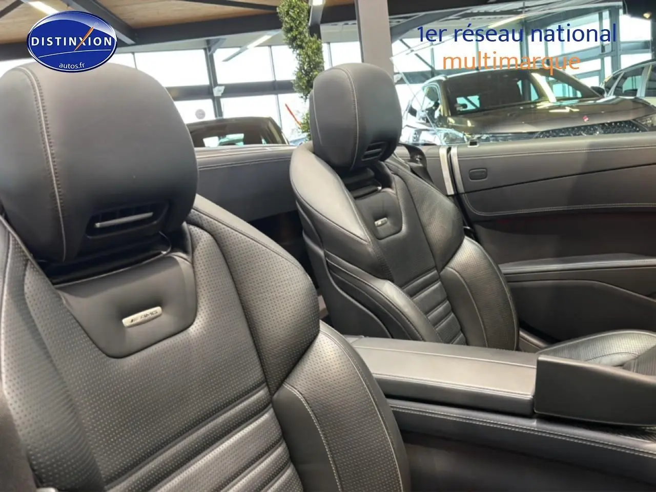 Gros plan sur les sièges avant en cuir noir perforé de la Mercedes Classe SL 63 AMG, intérieur élégant et sportif.