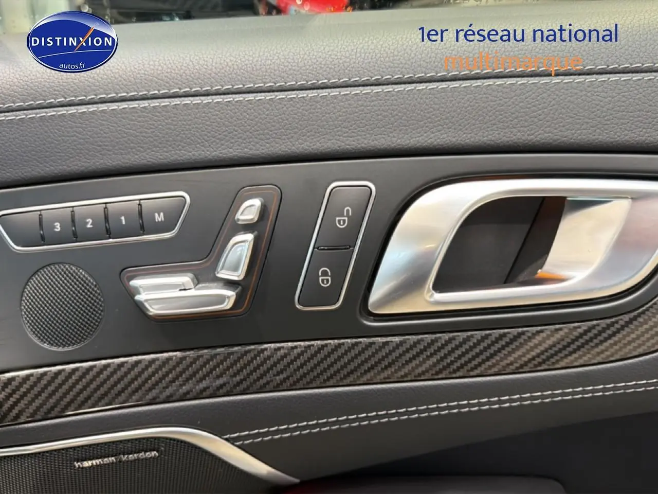 Détail de la porte côté gauche d’une Mercedes Classe SL 63 AMG 2013, avec commandes de siège et insert carbone.