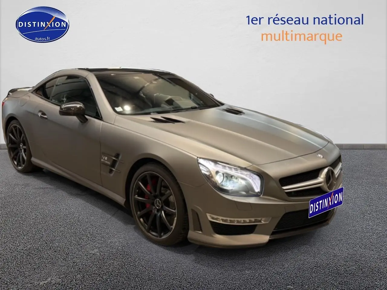 Mercedes Classe SL 63 AMG gris vue 3/4 avant droit avec jantes noires et feux allumés sur fond neutre.