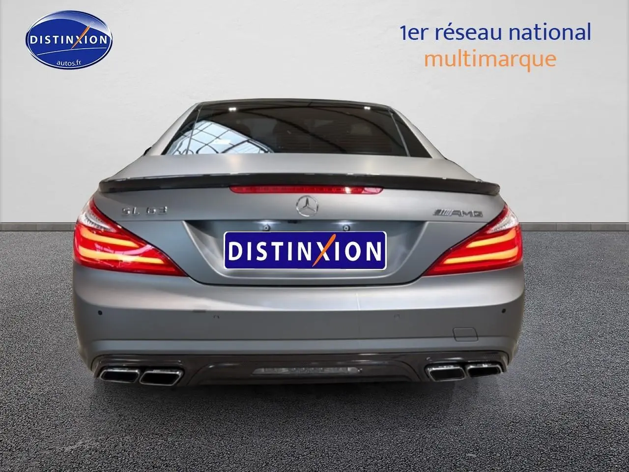 Vue arrière d'une Mercedes Classe SL 63 AMG gris métallisé avec becquet et quadruple sortie d'échappement.