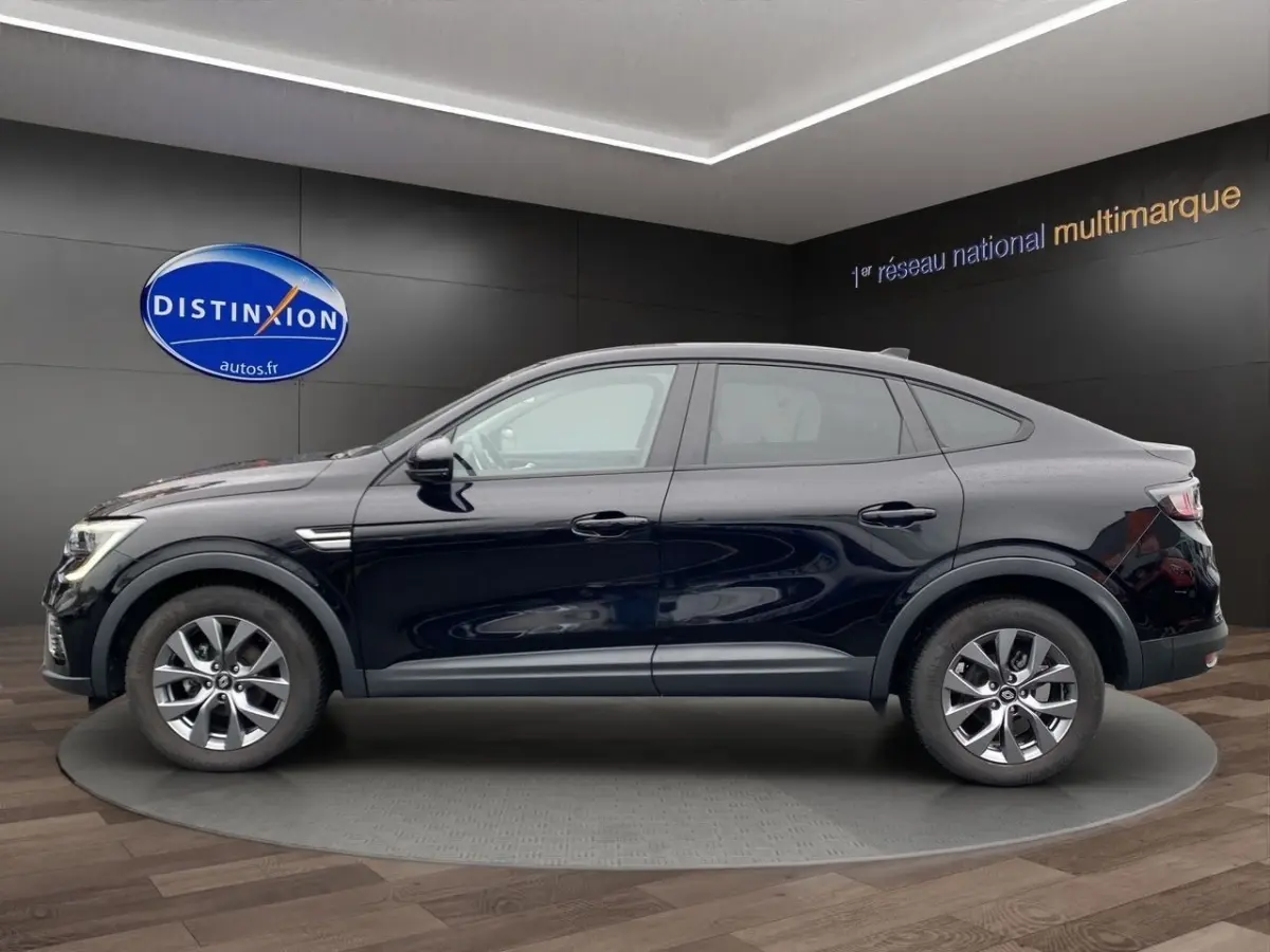 Profil droit d'un Renault Arkana noir 2024 en version Evolution mild hybrid, dans un showroom avec sol en bois.