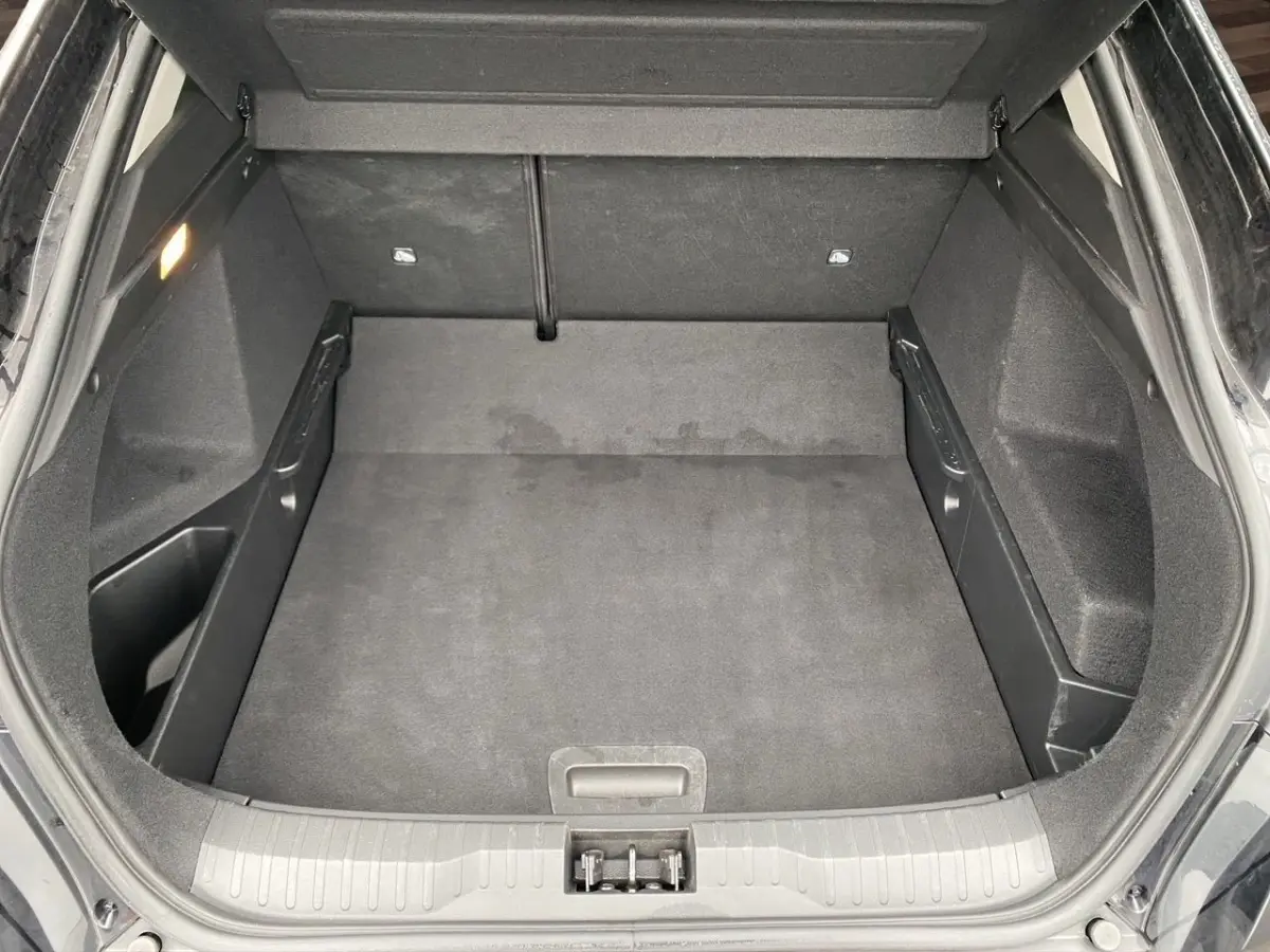Coffre ouvert vu de dessus du Renault Arkana noir, montrant un espace de chargement propre et bien fini.
