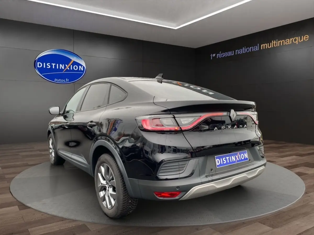 Vue 3/4 arrière droite d'une Renault Arkana noire 2024 avec feux LED et spoiler de coffre visible.