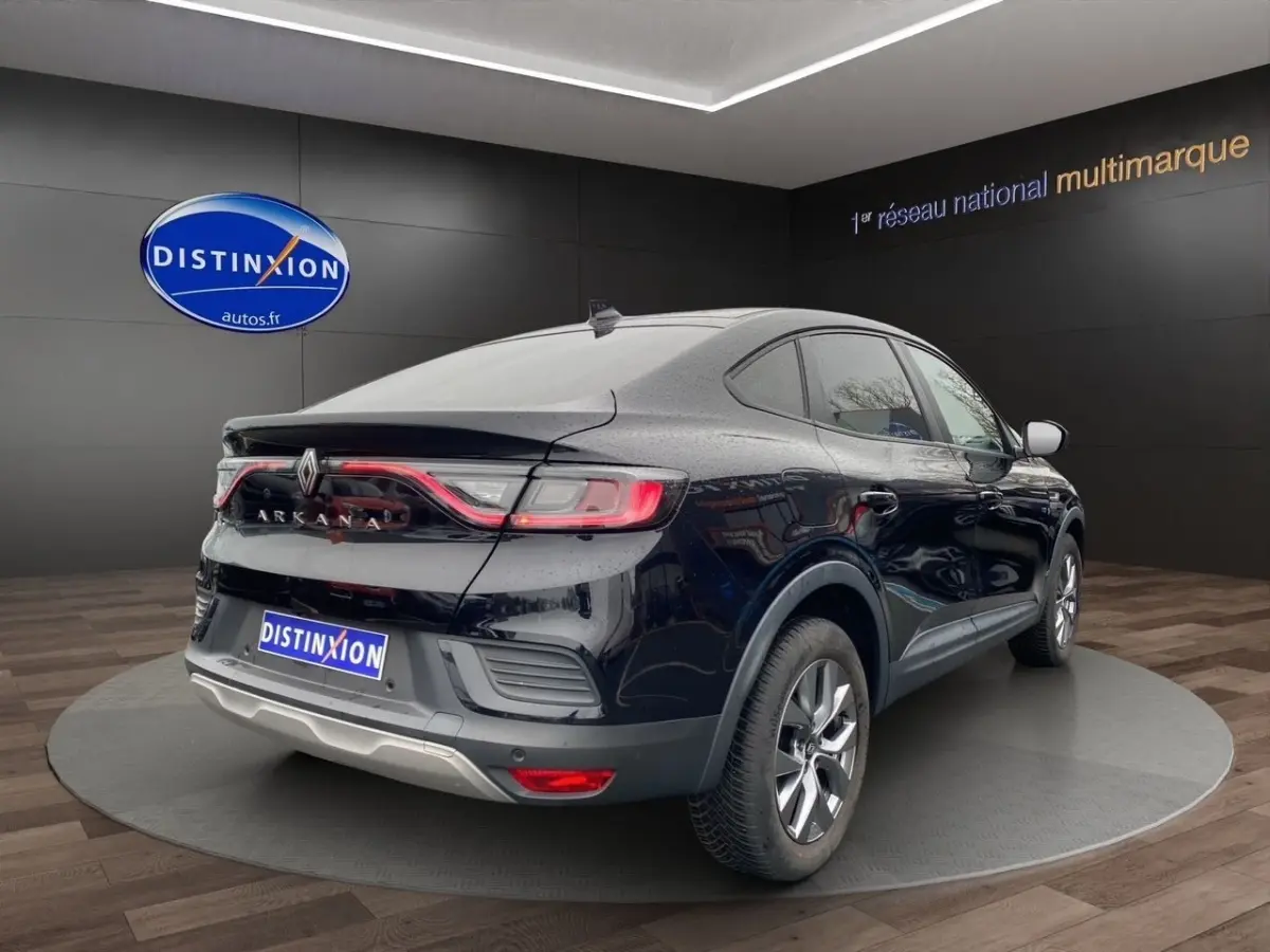 Vue 3/4 arrière droite d'une Renault Arkana noire 2024 avec feux arrière LED et spoiler de coffre.