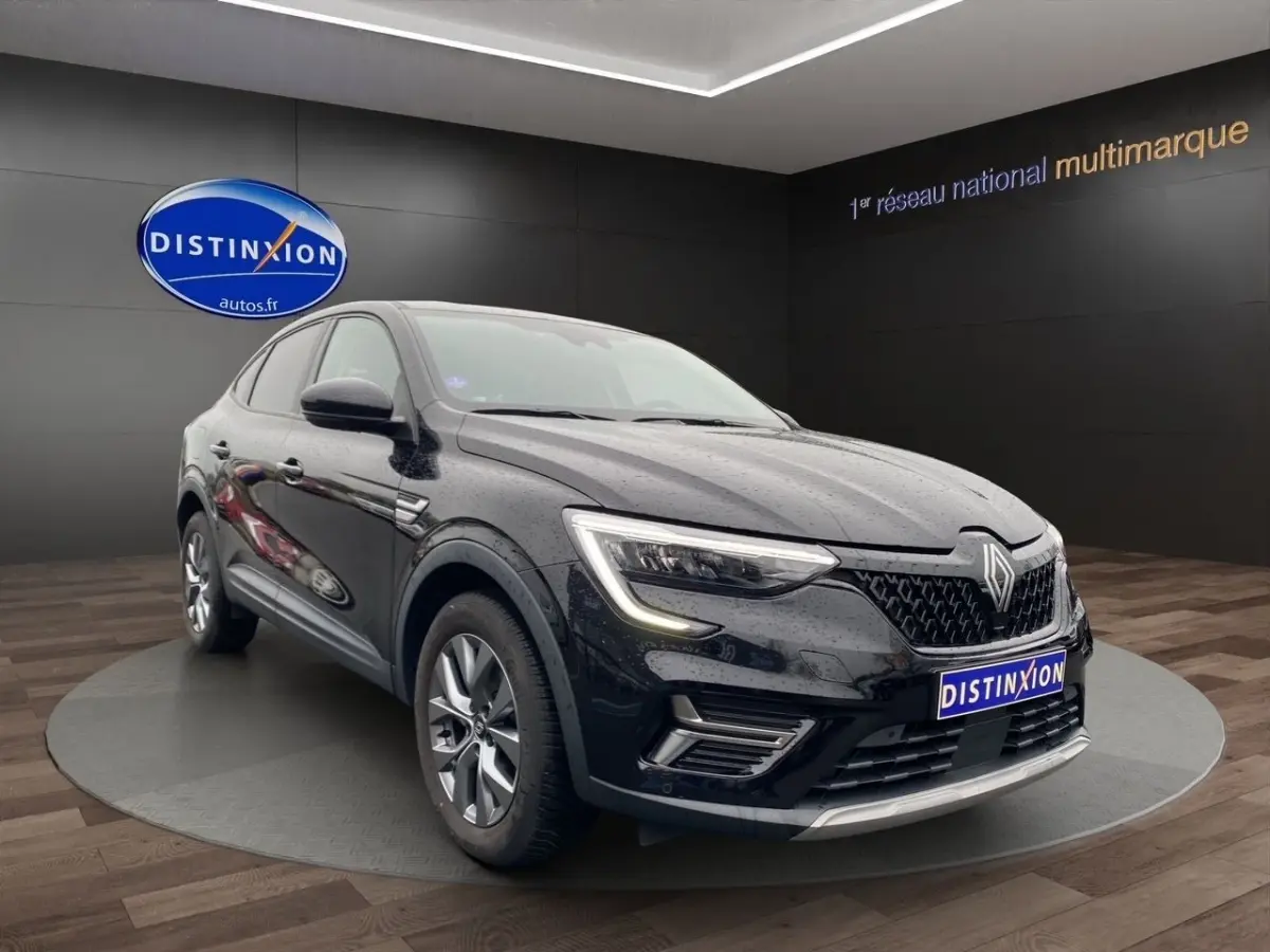 Renault Arkana noir vue 3/4 avant droit, avec calandre distinctive et feux LED allumés en showroom.