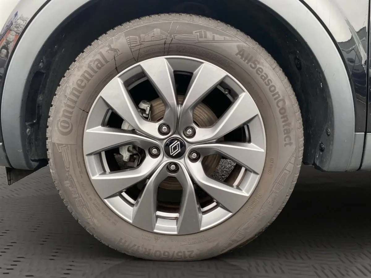 Gros plan sur la roue avant gauche noire du Renault Arkana Evolution avec jante alliage argentée et pneu Continental.