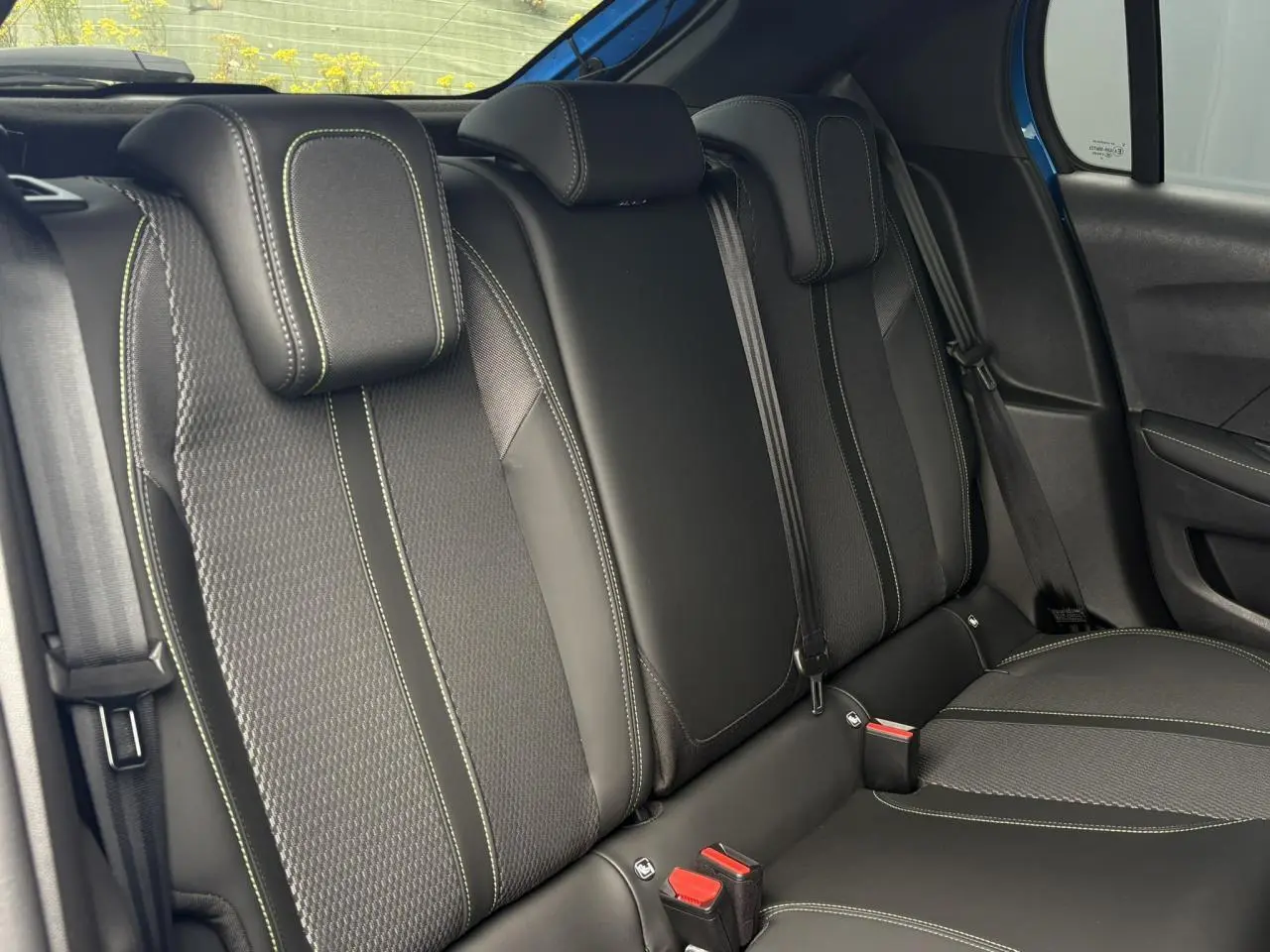 Vue latérale droite de la banquette arrière noire avec surpiqûres vertes de la Peugeot 208 Hybrid 110 e-DSC6 GT.