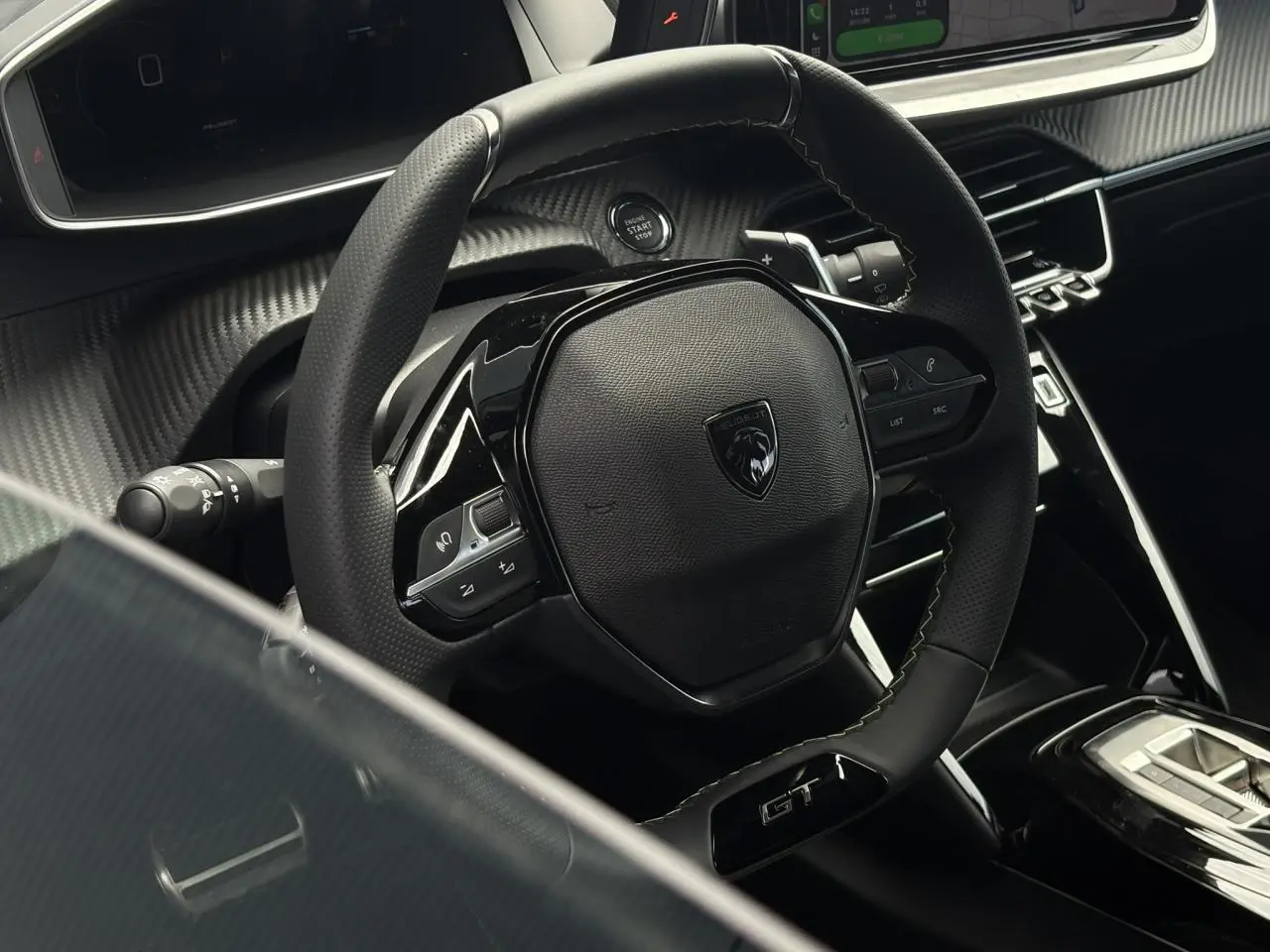 Vue rapprochée du volant compact cuir noir avec badge GT et commandes intégrées dans l’habitacle du Peugeot 208 Hybrid 2025.
