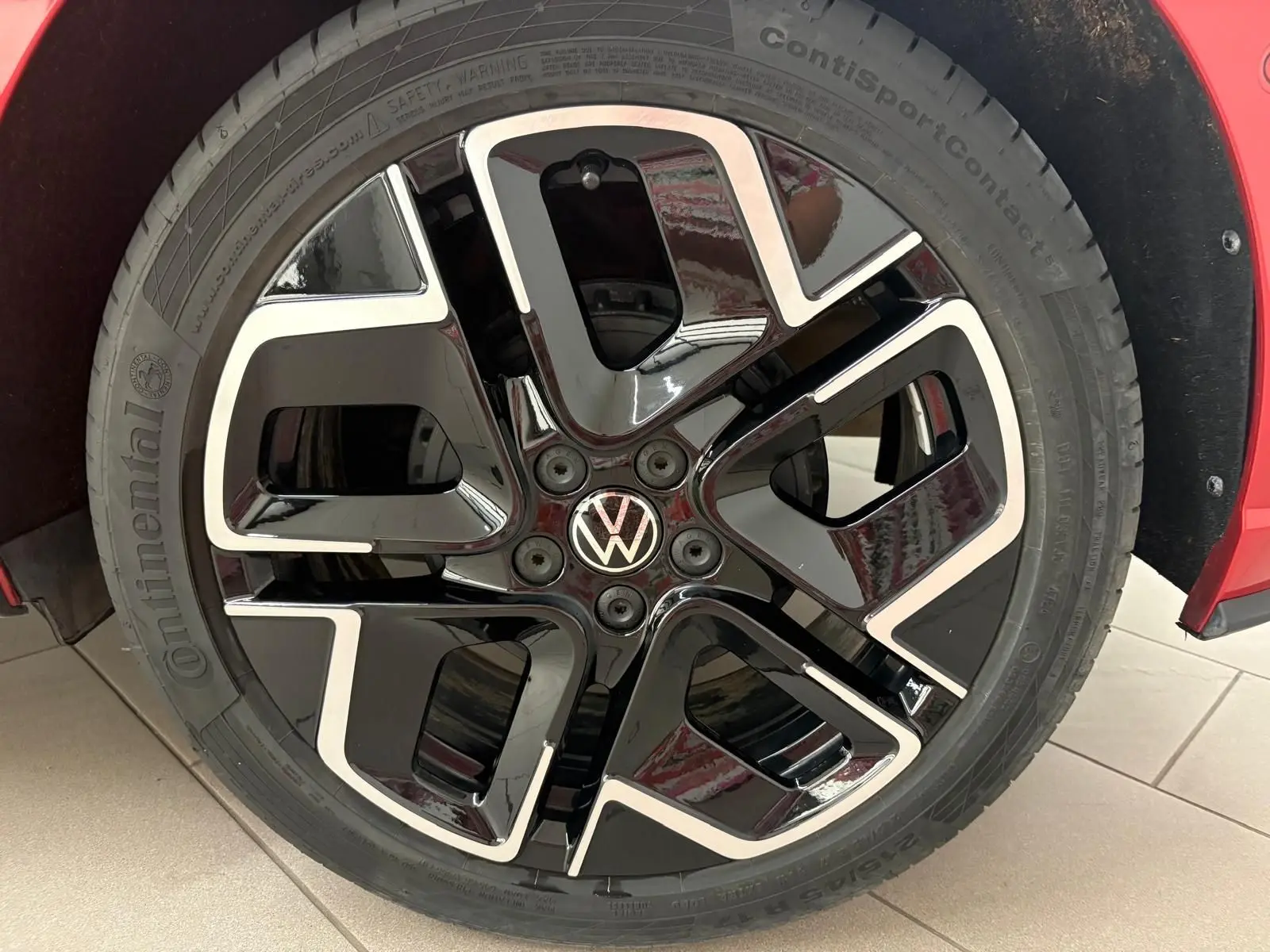 Gros plan sur la jante noire et argentée au design R-Line d’une Volkswagen Polo Rouge Roi 2025.