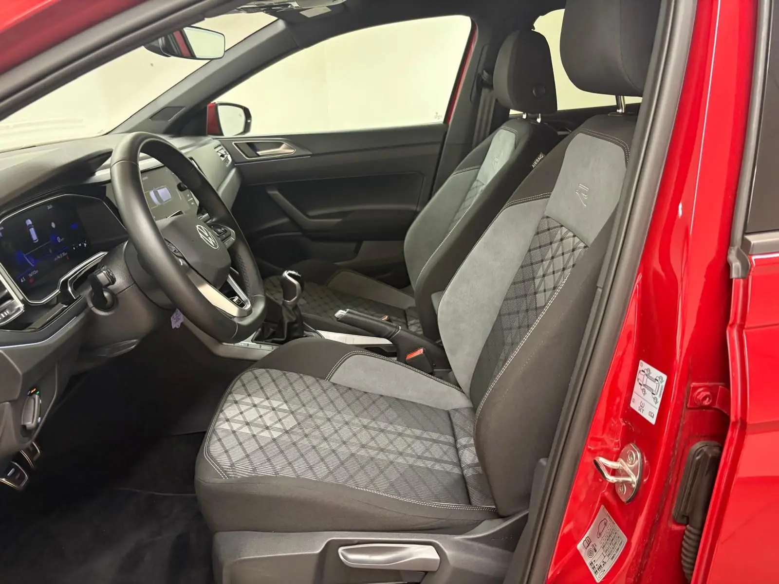 Vue intérieure côté conducteur de la Volkswagen Polo Rouge Roi 2025, sièges R-Line avec surpiqûres et volant multifonction.