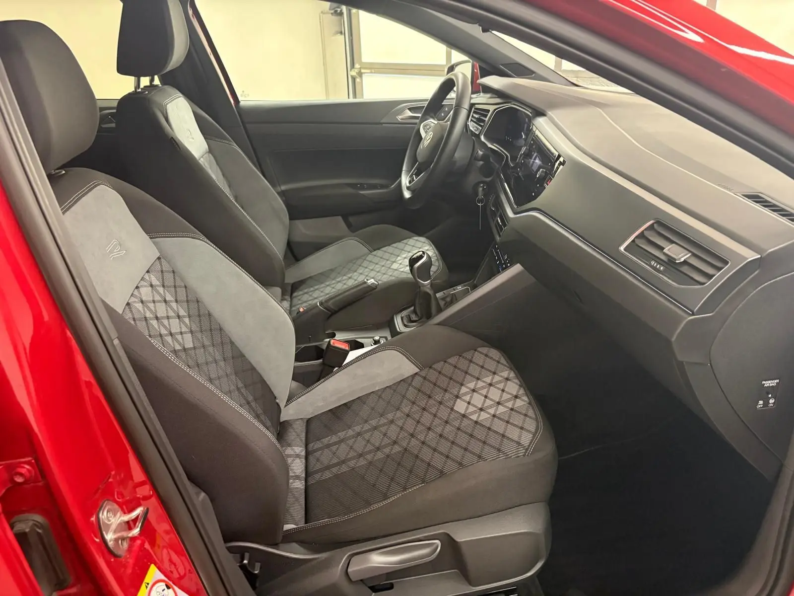 Vue intérieure côté conducteur de la Volkswagen Polo Rouge Roi 2025 avec sièges R-Line en tissu et alcantara.