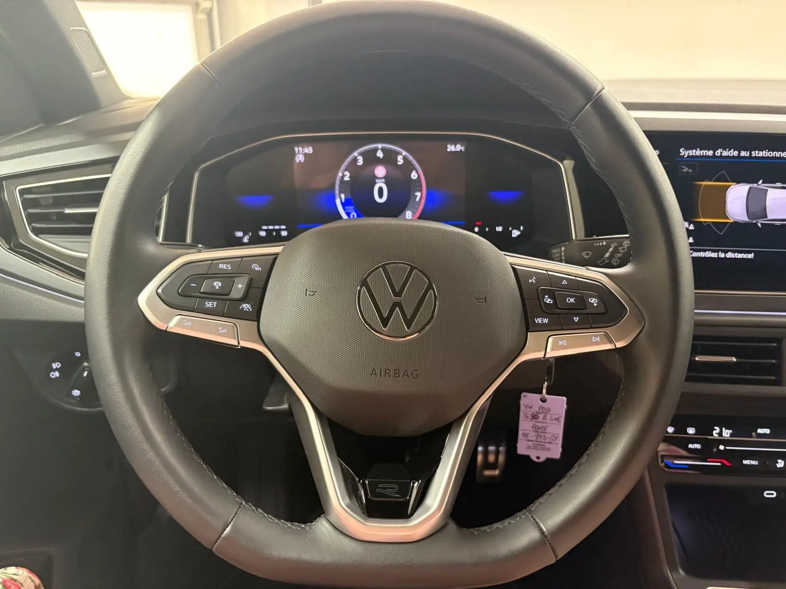 Vue rapprochée du volant multifonction noir avec logo VW et tableau de bord digital d'une Volkswagen Polo 2025.