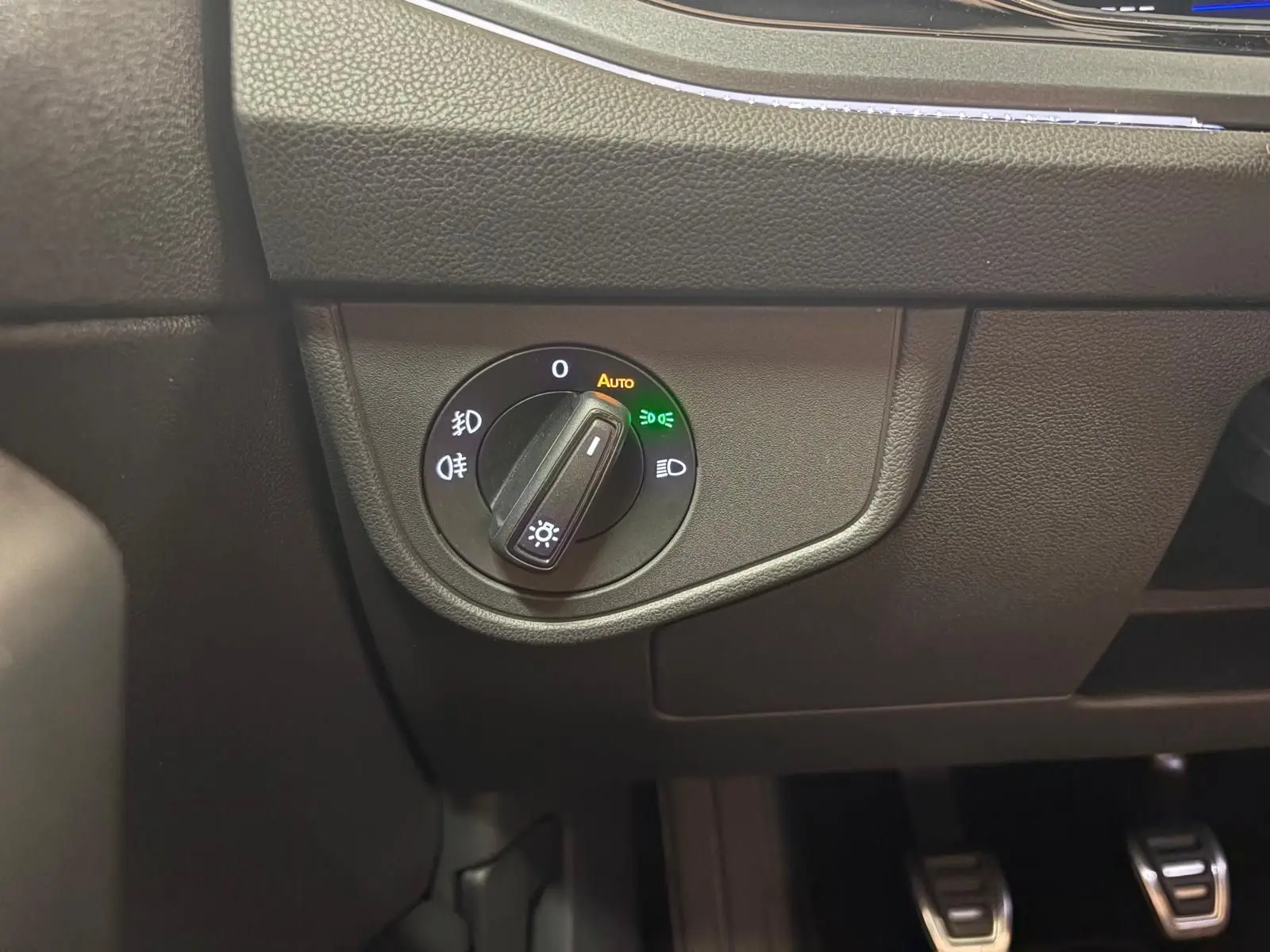 Gros plan sur le sélecteur d'éclairage intérieur noir du Volkswagen Polo Rouge Roi, côté gauche du tableau de bord.