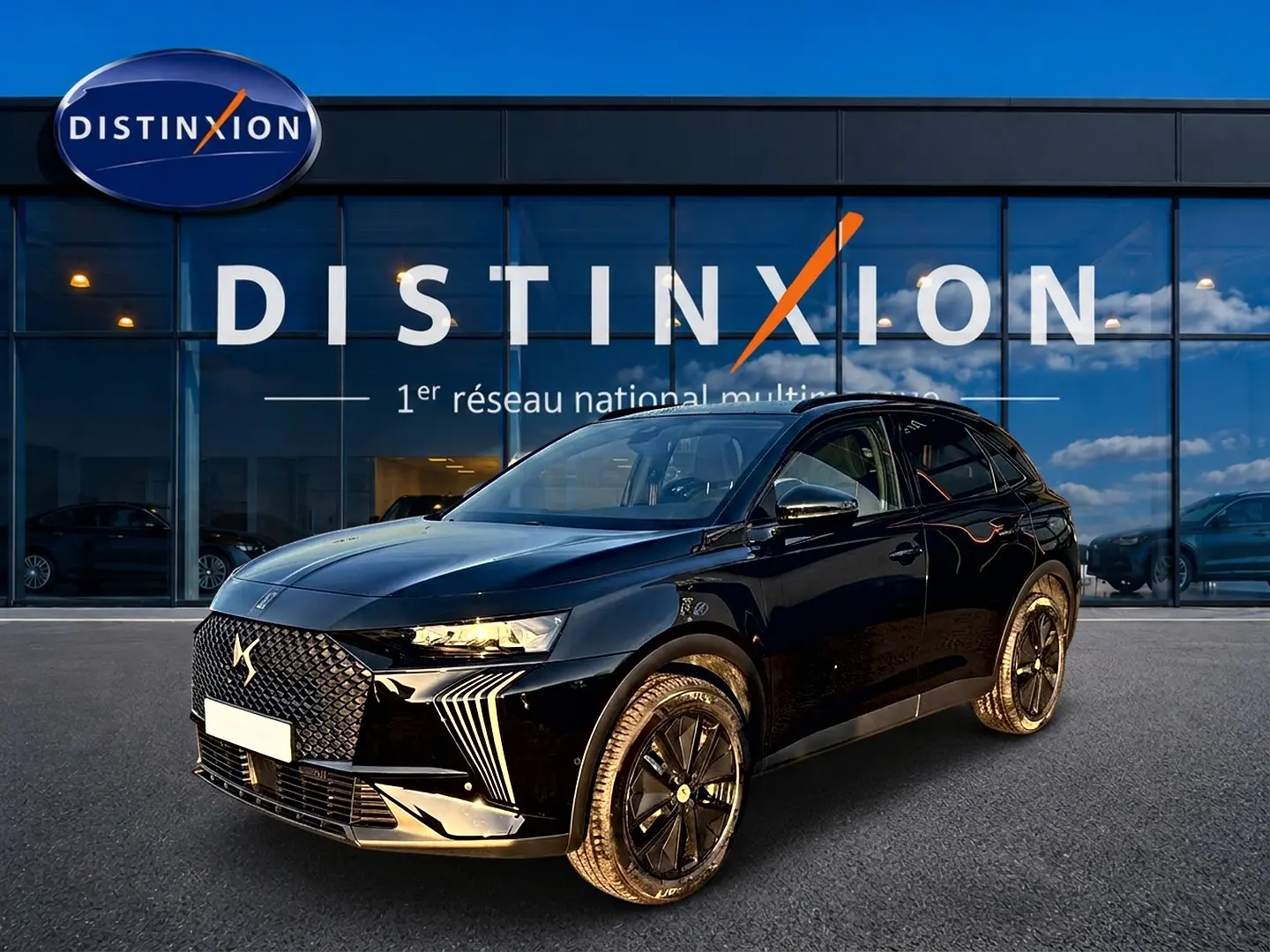 DS7 1.5 BlueHDi noir en 3/4 avant droit, avec calandre distinctive et jantes alliage noires devant showroom Distinxion.