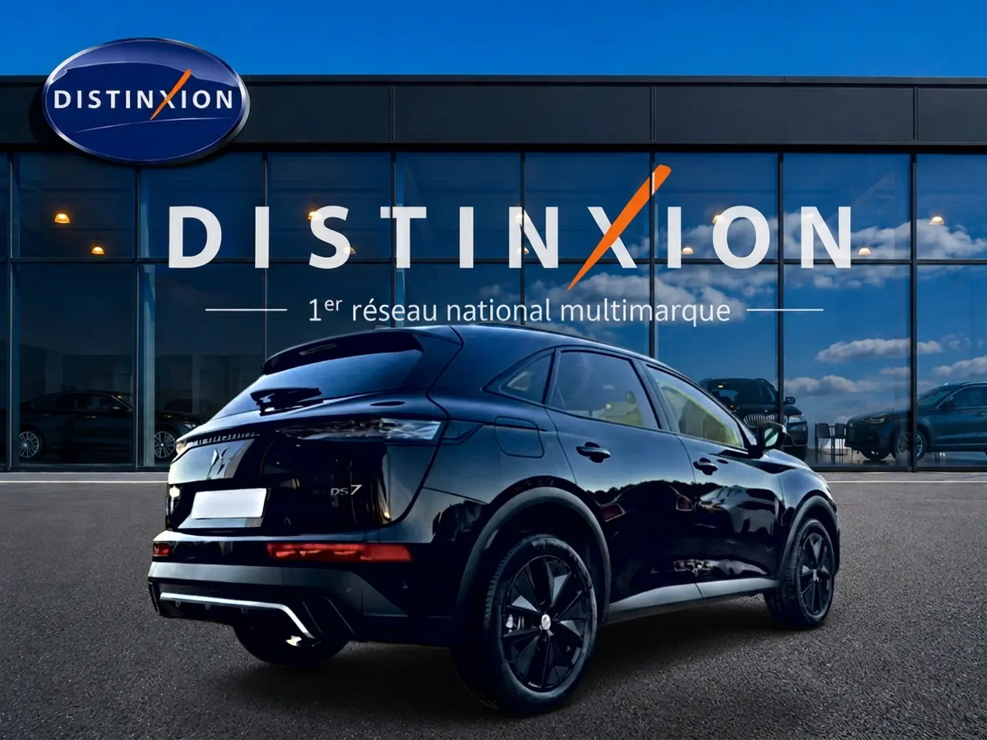 Vue 3/4 arrière droite du SUV DS7 noir brillant avec jantes noires, devant une vitrine Distinxion.