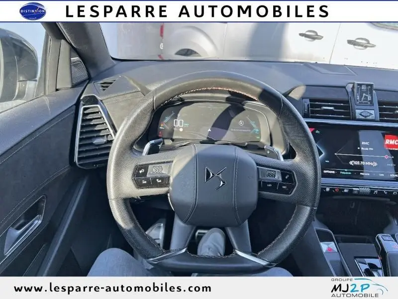 Vue centrée sur le volant cuir noir du DS7 Crossback gris, avec tableau de bord numérique et écran tactile visible.