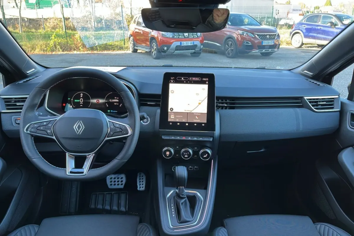Vue intérieure avant de la Renault Clio V E-Tech 145 Esprit Alpine Bose 2025, tableau de bord noir avec écran tactile vertical et volant multifonctions.