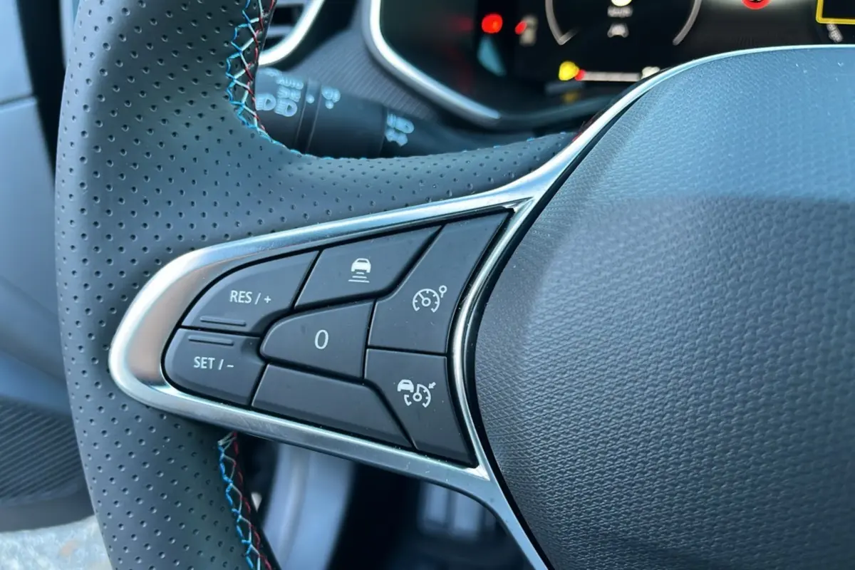 Gros plan sur le côté gauche du volant cuir perforé de la Renault Clio V E-Tech 145 Esprit Alpine Bose 2025.