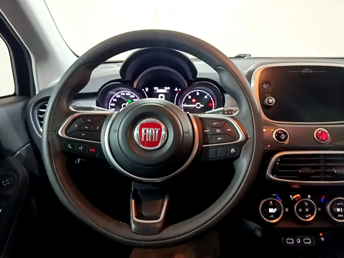 Vue intérieure centrée sur le volant et le tableau de bord du Fiat 500X 2019, avec écran tactile et commandes au volant.