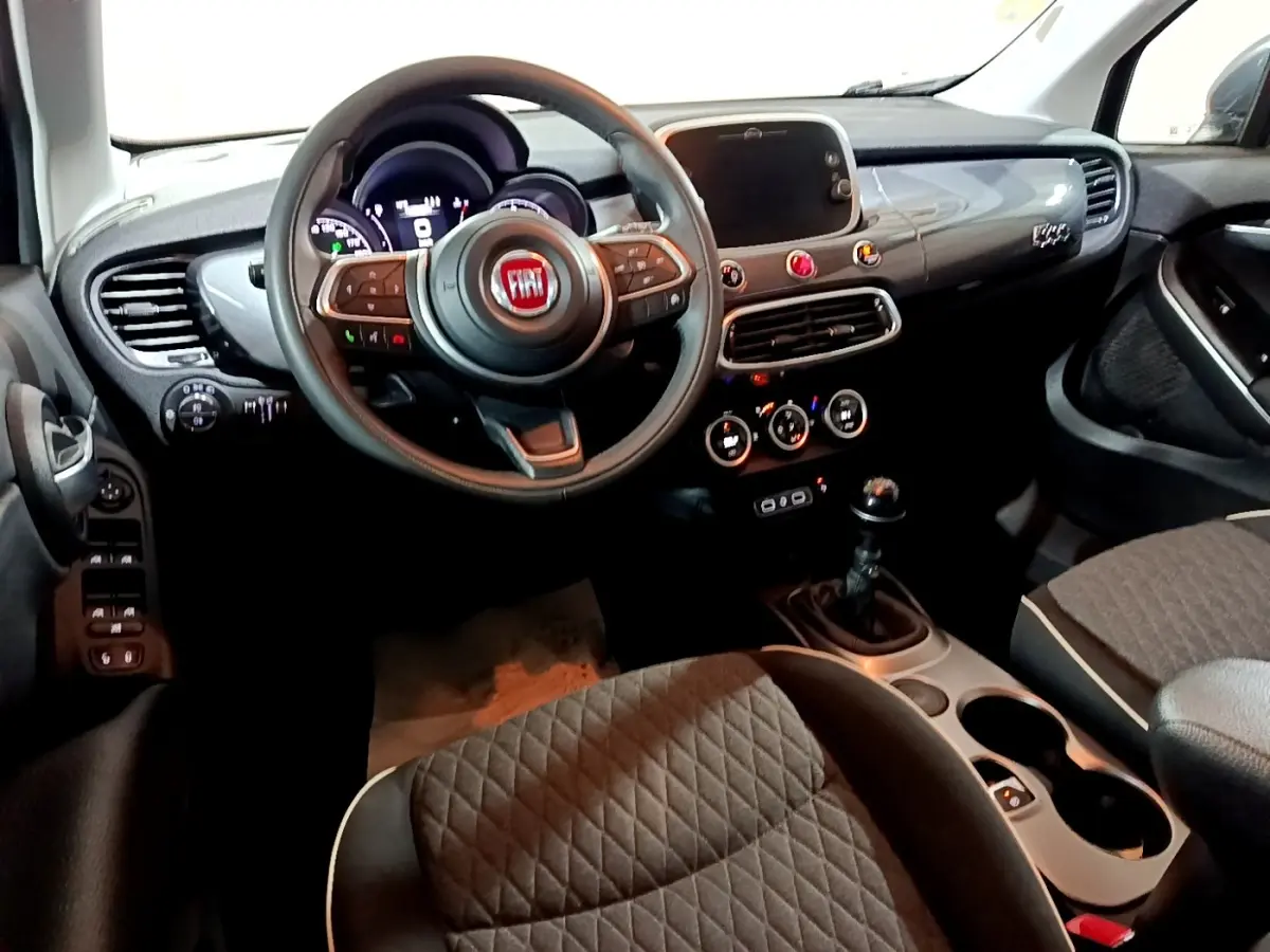 Vue intérieure avant droite du tableau de bord et volant noir de la Fiat 500X City Cross 2019 avec boîte manuelle.