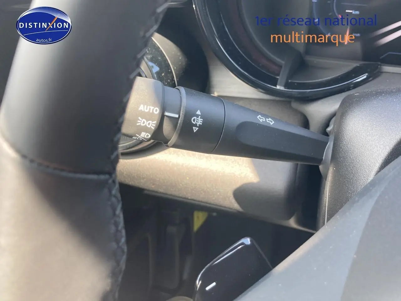 Gros plan sur la manette de clignotants et feux, intérieur noir de l'Alfa Romeo Junior 1.2 hybride 2026.