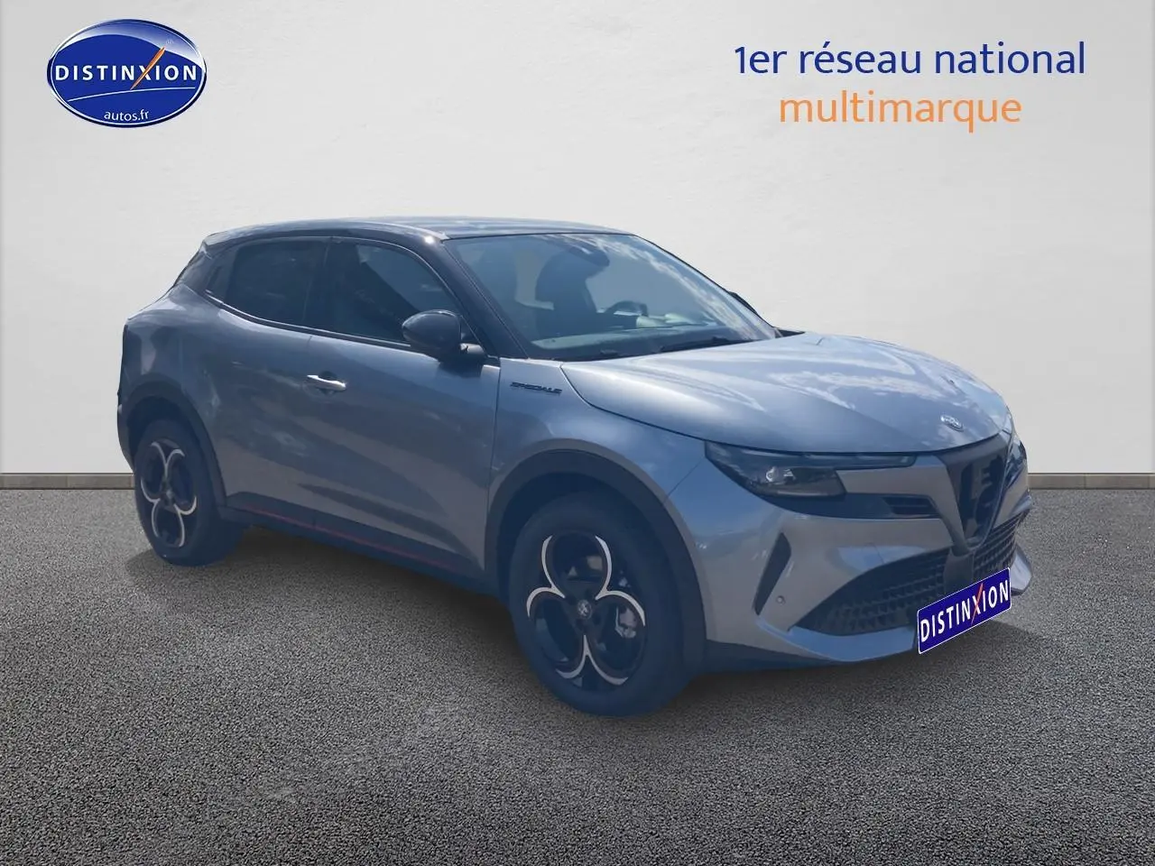 Alfa Romeo Junior 1.2 hybride gris t/noir en 3/4 avant droit avec jantes alliage et vitres teintées.