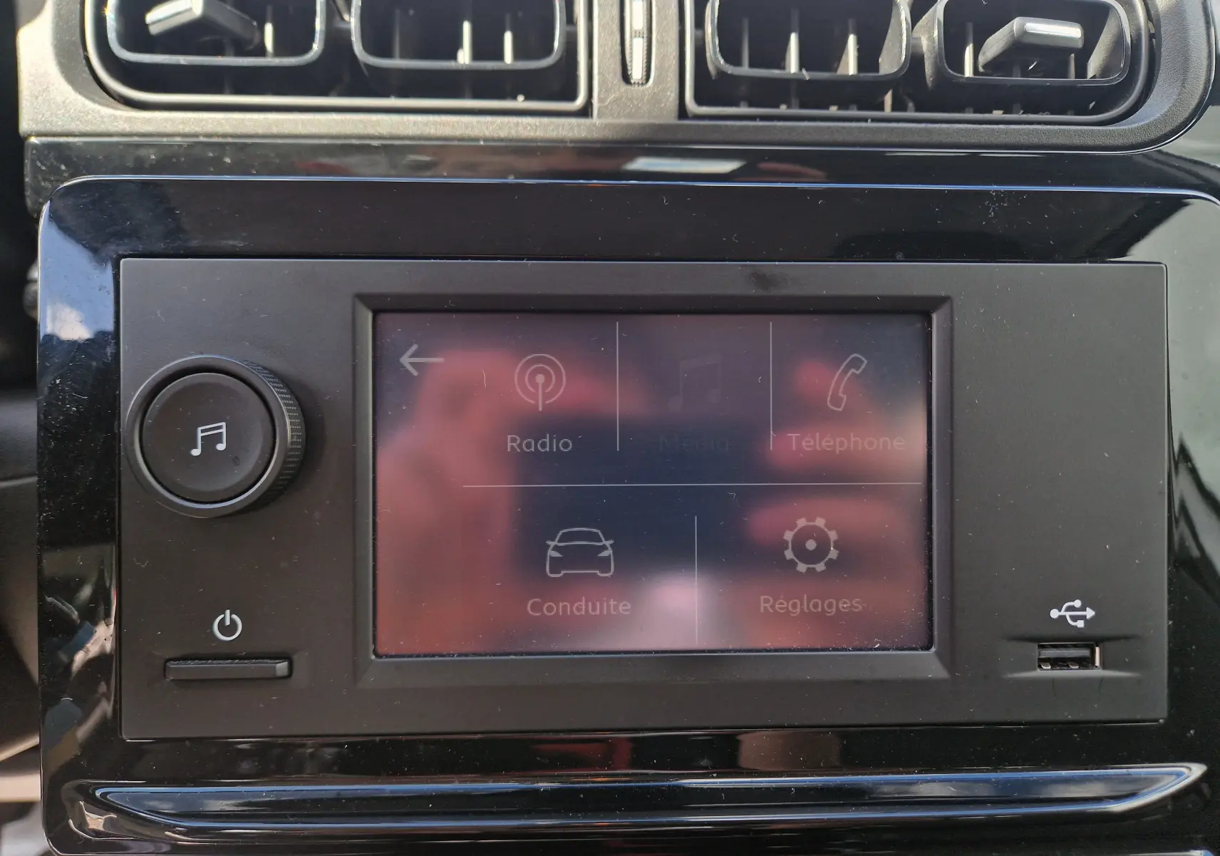 Gros plan sur l’écran tactile central et les aérateurs supérieurs du tableau de bord d’une Citroën C3 Société blanche.
