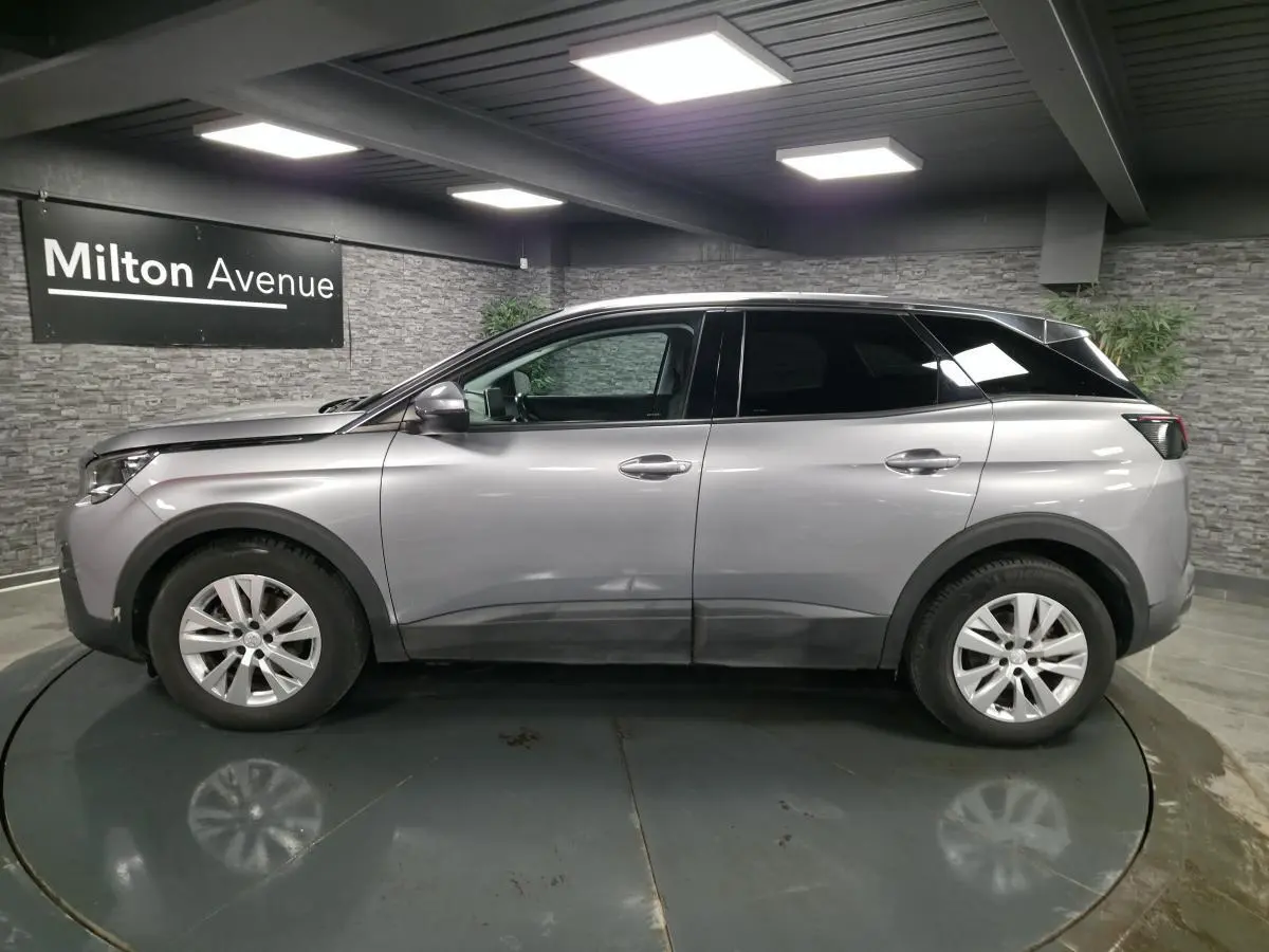 Profil droit d'un Peugeot 3008 gris métallisé 2018 en intérieur avec jantes alliage 17 pouces.