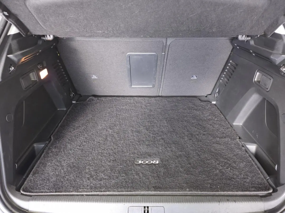 Coffre ouvert du Peugeot 3008 gris, vue intérieure montrant le tapis de sol avec logo 3008.