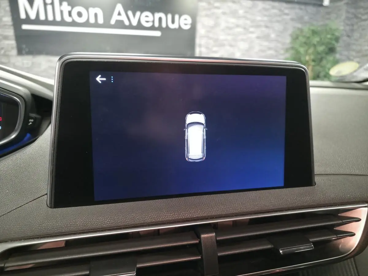 Écran tactile intérieur affichant l'aide au stationnement du Peugeot 3008 gris, vue centrée sur la console.