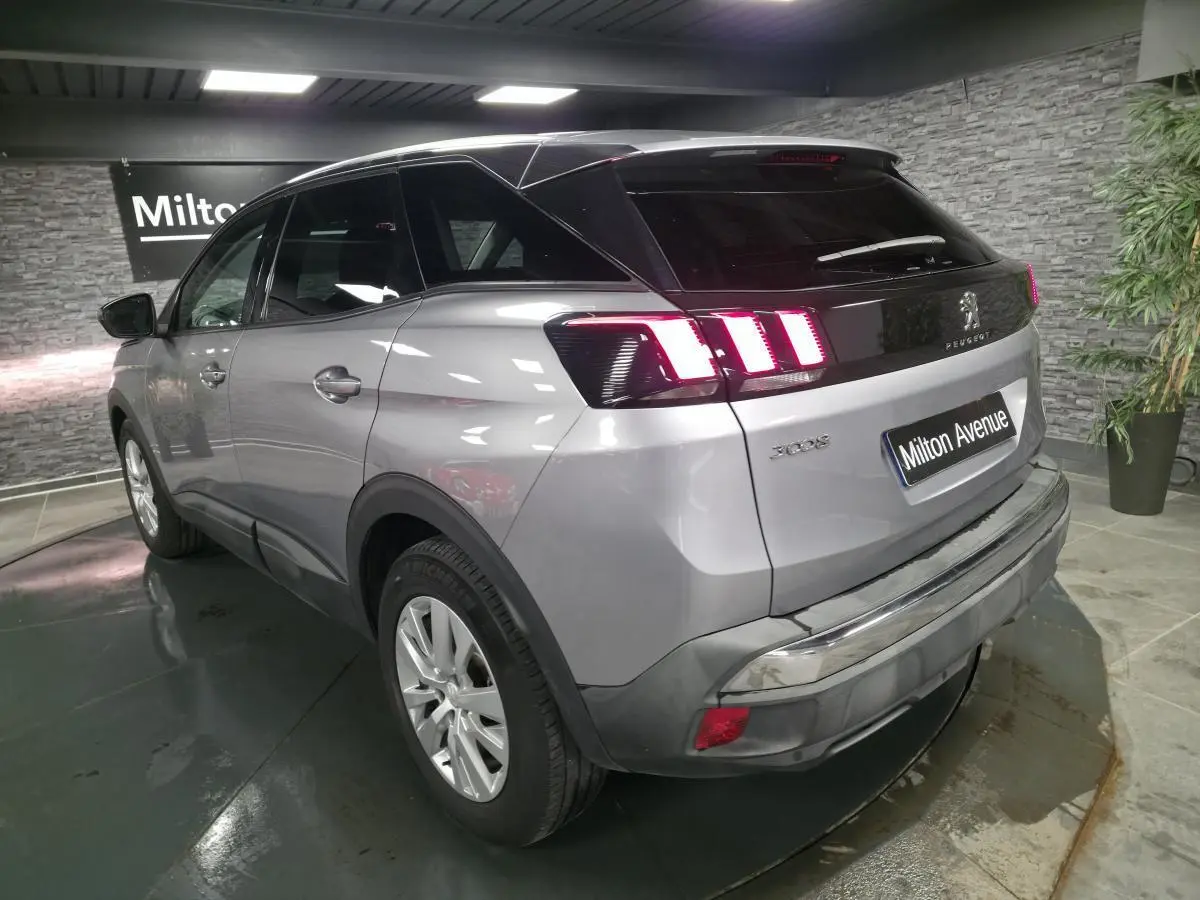 Vue 3/4 arrière droite d’un Peugeot 3008 gris métallisé avec feux arrière LED et jantes alliage 17 pouces.