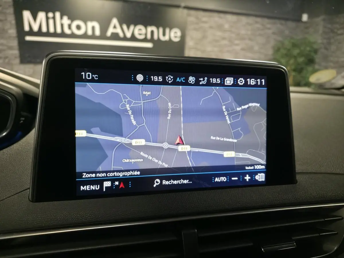 Écran tactile central du Peugeot 3008 gris, affichant la navigation GPS avec carte et informations climatiques.