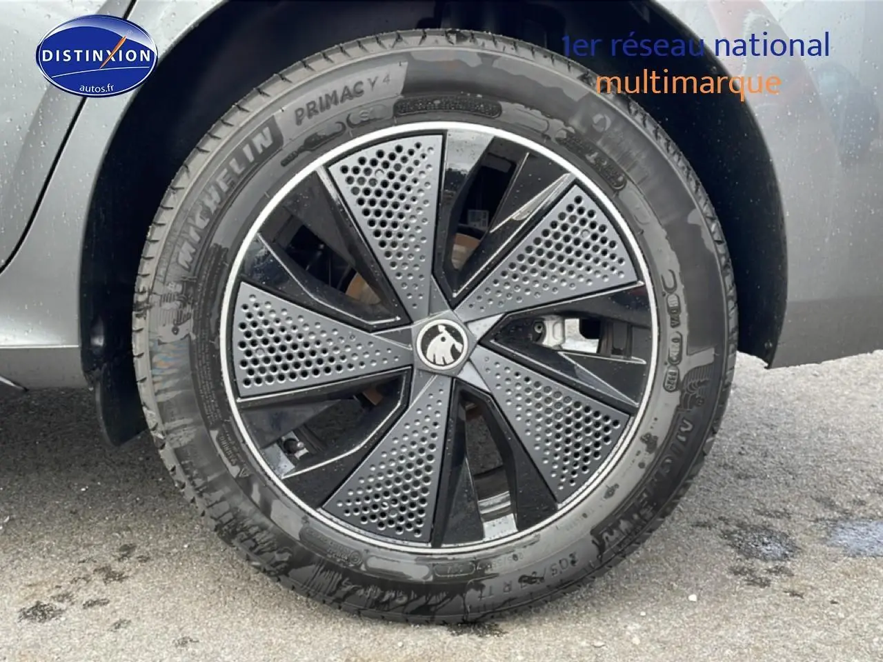 Gros plan sur la roue avant gauche gris graphite d’un Skoda Kamiq avec jante alu noire et grise à motifs perforés.