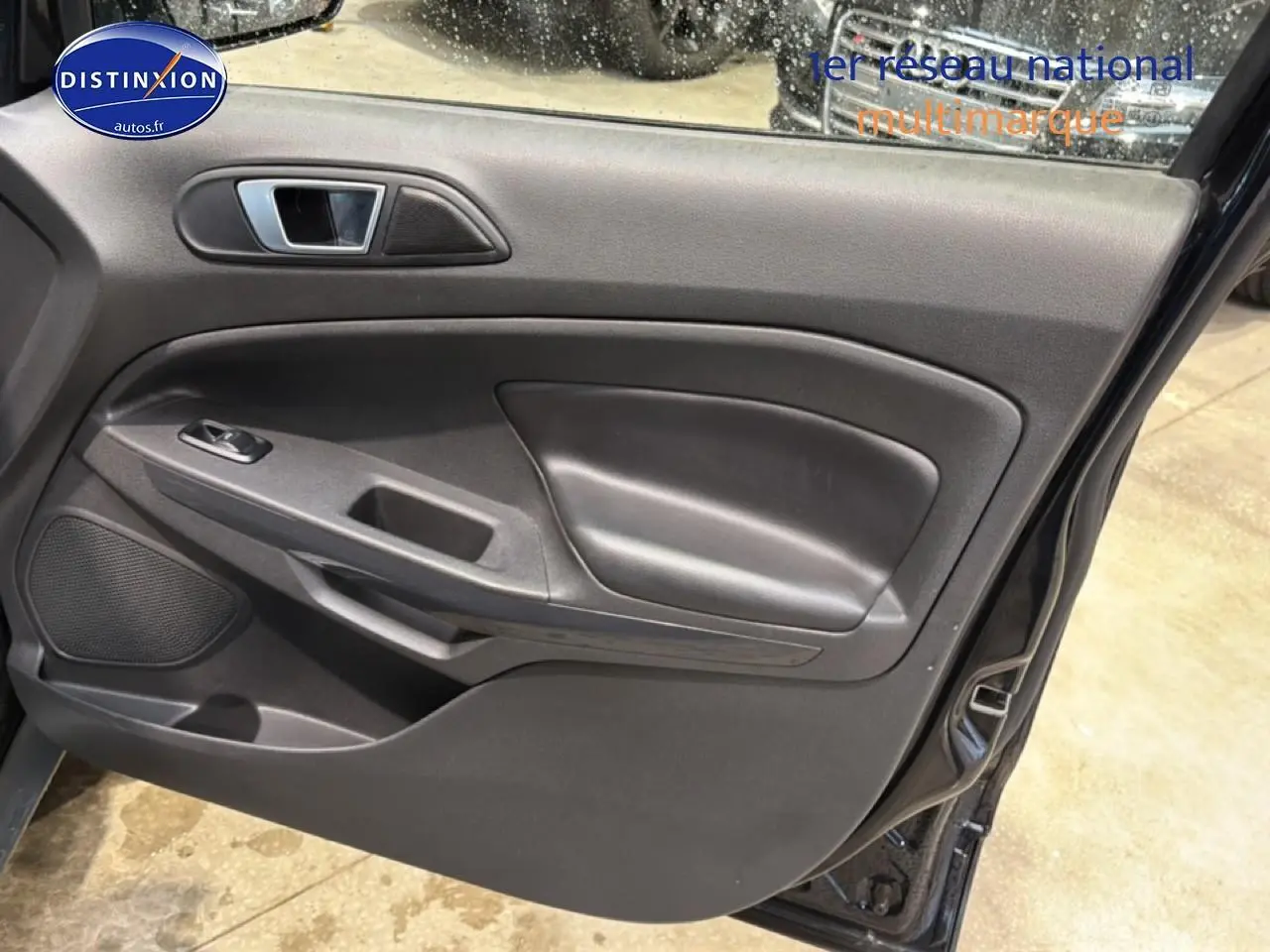Vue intérieure de la porte avant gauche noire du Ford EcoSport 2017, avec commande de fenêtre et haut-parleur intégré.