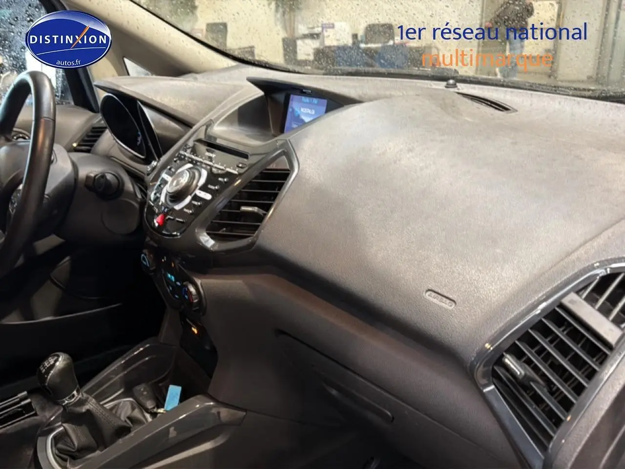 Vue intérieure côté passager du tableau de bord noir du Ford Ecosport 2017 avec console centrale et levier de vitesse manuel.