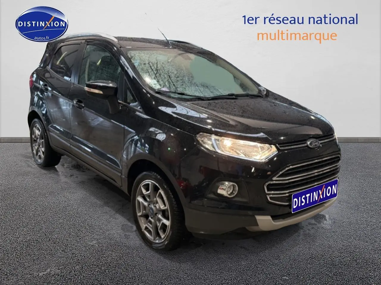Ford EcoSport noir vue 3/4 avant droit, avec jantes alu et barres de toit visibles en intérieur showroom.