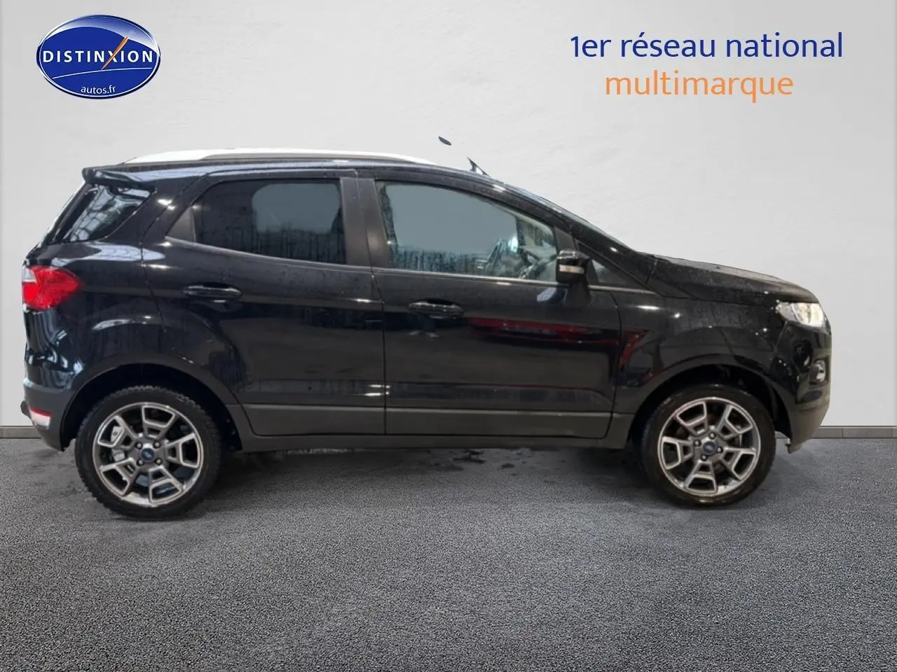 Ford EcoSport noir vu de profil côté gauche avec jantes alliage et barres de toit blanches.