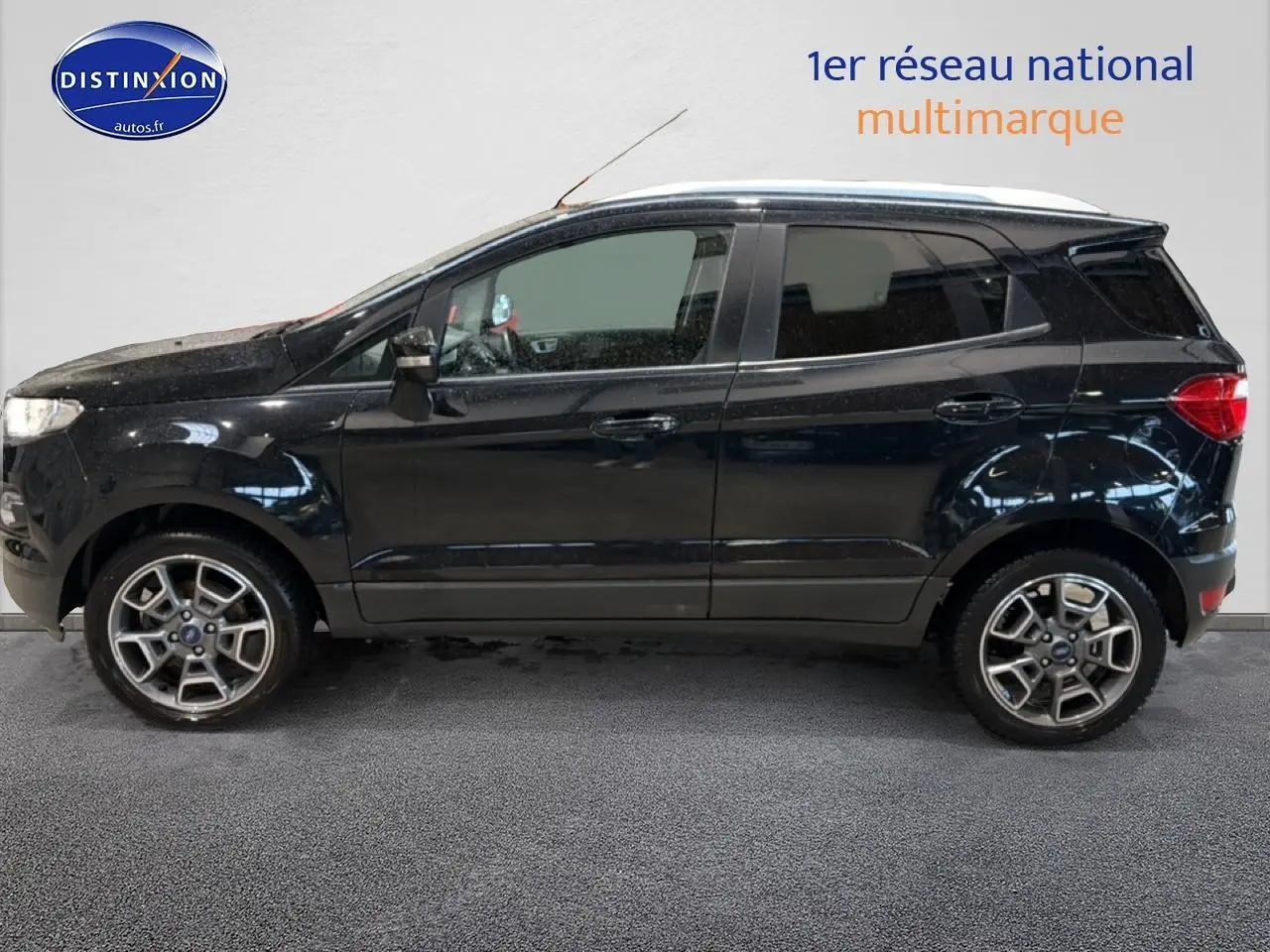 Ford EcoSport noir vu de profil côté gauche, avec jantes alliage et barres de toit blanches.
